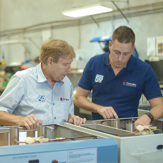 Workers inspecting laboratory ovens during manufacturing processes